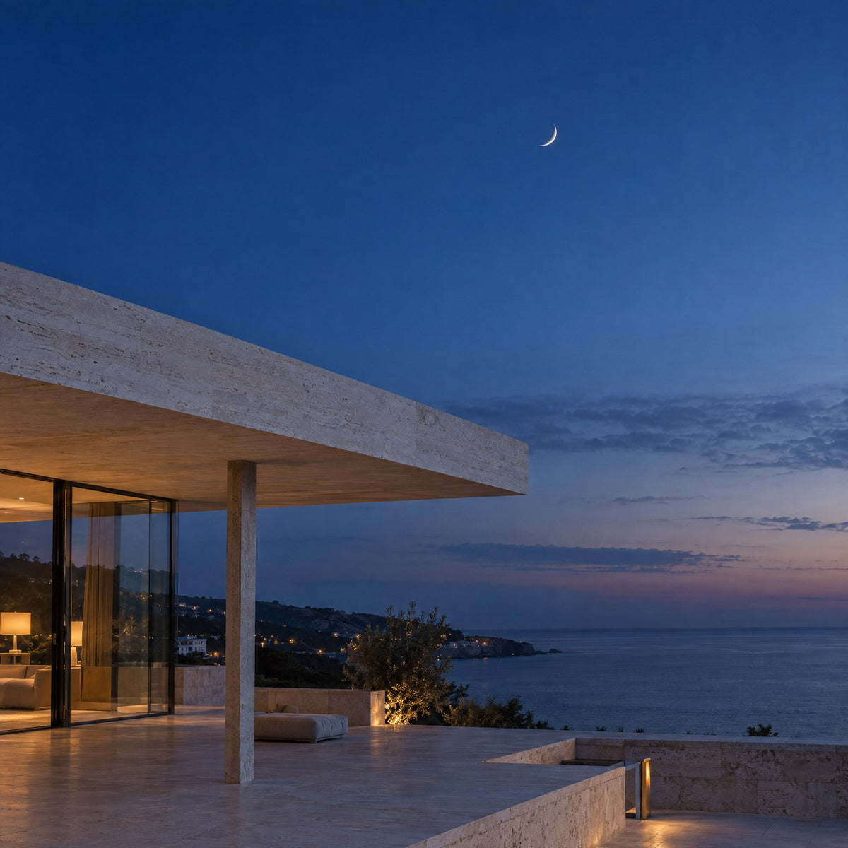 A pale limestone roof edge against a deep blue night sky with a small crescent moon