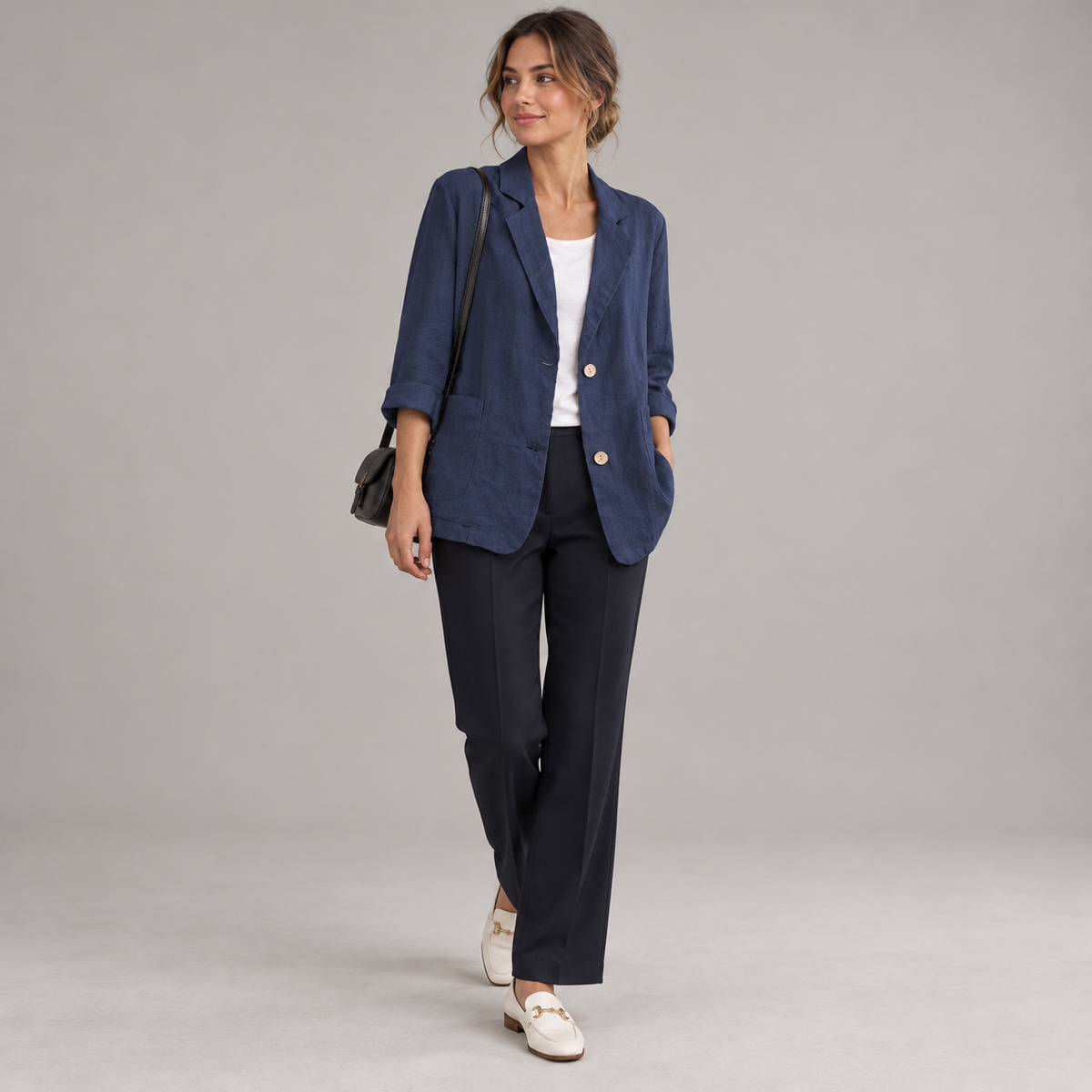 Women's relaxed fit two button blazer with roll-up sleeves on a model, angled front view